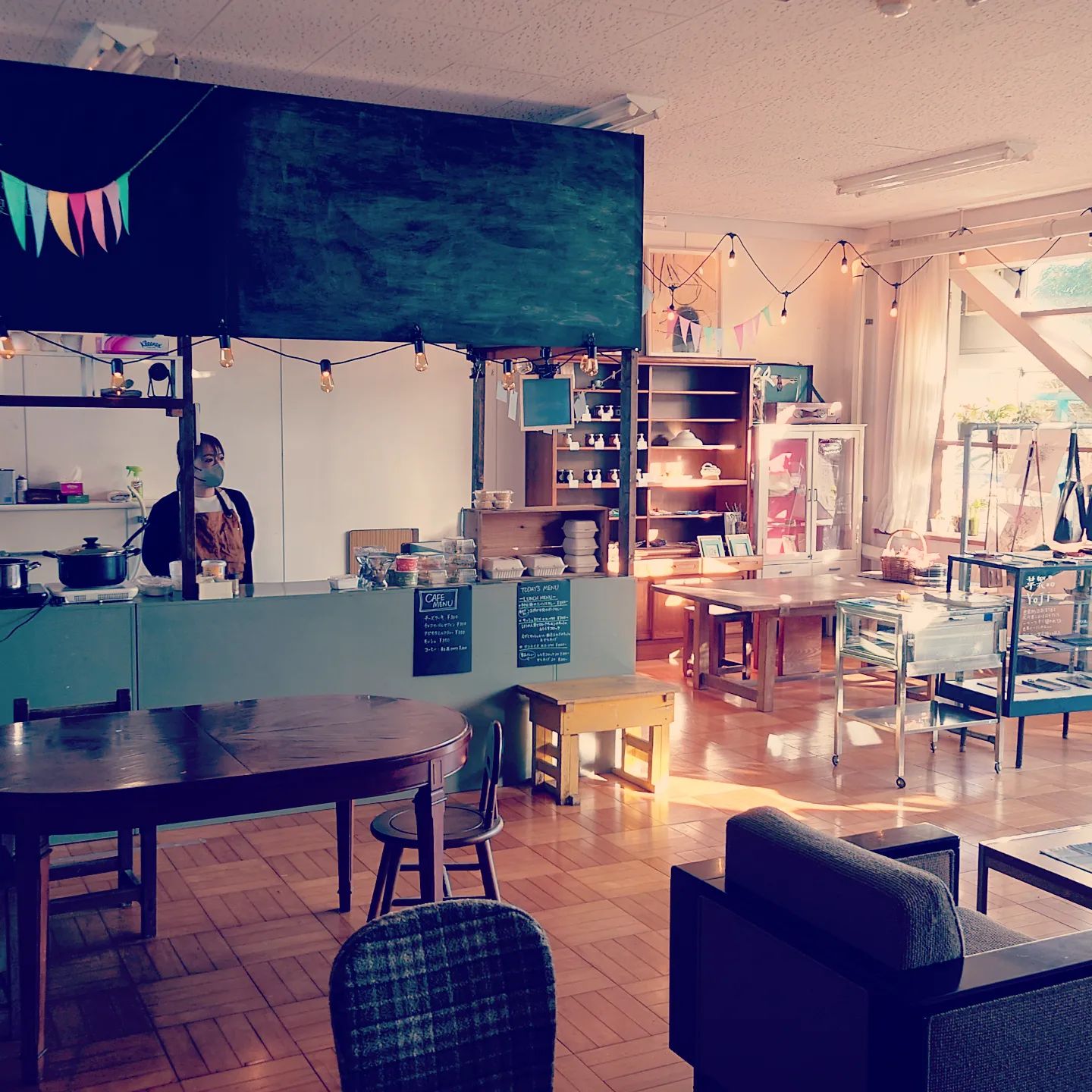 キッサテンホケンシツの温かい雰囲気。木のテーブルとイス、やわらかな自然光が差し込む空間